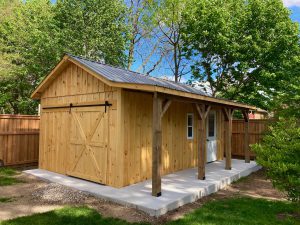 High gable shed with side porch on concrete base